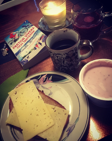 Frukost i Motala med kaffe, ostsmörgås, yoghurt, bok och tänt ljus