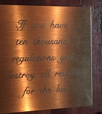 Skylt som det står "If you have ten thousand regulations you will destrou all respect for the law" på.