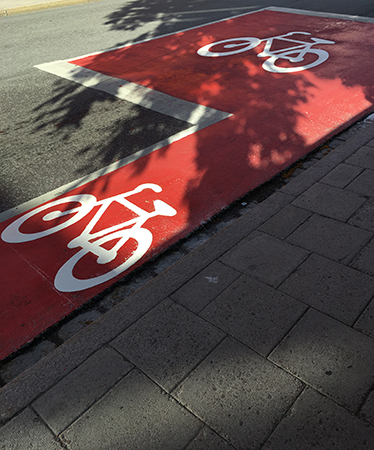 Vita cyklar målade på röda fält på gatan