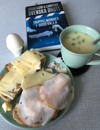 Lunch med mackor kokt ägg varma koppen och boken Trippelmordet
