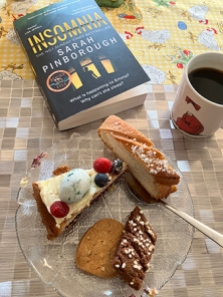 Kaffe tårtbit kardemummaskiva kakor och boken Insomnia