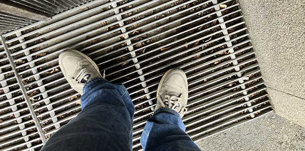 Mina fötter i gympadojor utanför porten på Storgatan